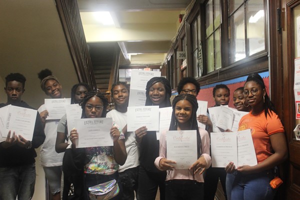 Eighth-grade students are proud to hold their honor roll certificates.